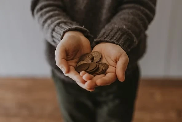 Person holding coins under financial pressure - financial stress and addiction